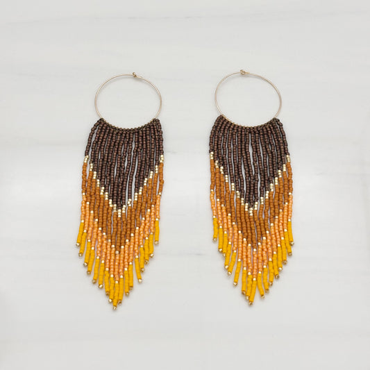 A pair of gold-filled frame bead fringe earrings with a geometric pattern, featuring colors brown, yellow, and orange.